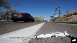 A vehicle goes by the scene of Sunday's fatality where a pedestrian was stuck by an Uber vehicle in autonomous mode, in Tempe, Ariz., March 19, 2018. 