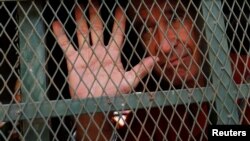 រូបឯកសារ៖ លោក​ James Ricketson អ្ន​កផលិត​ភាព​យន្ត​ឯកសារ​ជនជាតិ​អូស្ត្រាលី បានលើក​ដៃ​ នៅ​ពេល​ដែល​លោក​ត្រូវបាន​នាំ​ខ្លួន​មក​ដល់​សាលាដំបូង​រាជធានីភ្នំពេញ កាលពីថ្ងៃទី១៥ ខែមិថុនា ឆ្នាំ២០១៨។