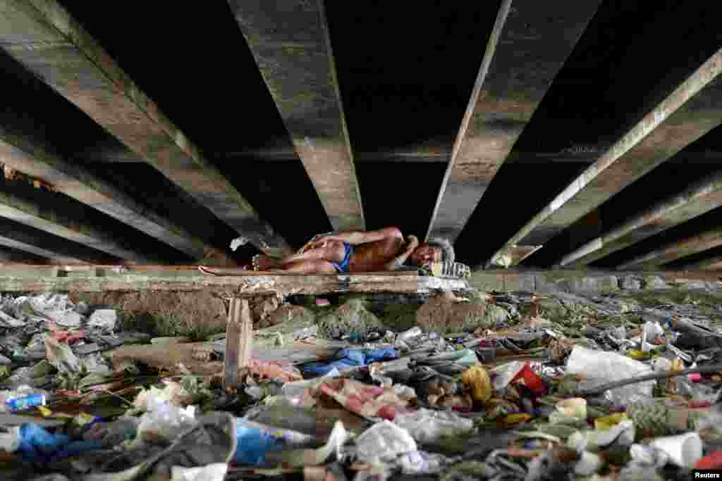 A man sleeps under a bridge in Paranaque city, Metro Manila, Philippines, May 31, 2016.