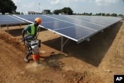 A Ugandan worker builds a solar plant in Soroti about 300 kilometers east of Uganda capital Kampala. In this electricity-starved rural part of Uganda, men ride bicycles several kilometers to the nearest market town simply to charge their phones.