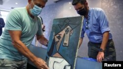 Lukisan 'Head of a Woman' Pablo Picasso ditampilkan saat presentasi kepada media di Athena, Yunani , 29 Juni 2021.(REUTERS/Costas Baltas)