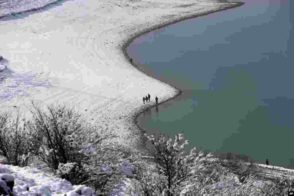 Afghans walk in the snow in the Paghman district of Kabul.