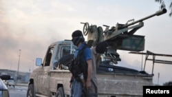 Fighters of the Islamic State of Iraq and the Levant (ISIL) stand guard at a checkpoint in Mosul, northern Iraq, June 11, 2014.