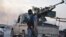 Fighters of the Islamic State of Iraq and the Levant (ISIL) stand guard at a checkpoint in Mosul, northern Iraq, June 11, 2014.