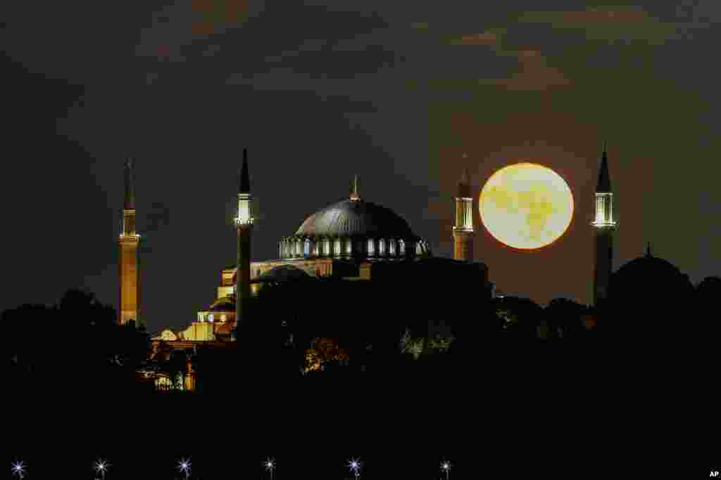 A full moon rises behind the Byzantine-era Hagia Sophia Mosque, in the historic Sultanahmet district of Istanbul, Turkey.