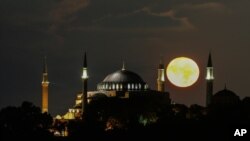 The full moon rises behind the Byzantine-era Hagia Sophia, in the historic Sultanahmet district of Istanbul, Sept. 1, 2020. 