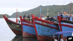 Bức hình chụp ngày 10 tháng 6 năm 2015 được Chính phủ Palau công bố cho thấy ngư dân Việt Nam ngồi trên tàu cá của mình neo đậu ở thành phố Koror, Palau sau khi bị bắt giữ vì đánh bắt hải sâm trái phép trong vùng biển của đảo quốc nhỏ bé này.