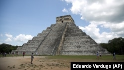  FILE - In this Aug. 3, 2018 file photo, tourists walk at the Mayan ruins of Chichen Itza in Mexico's Yucatan Peninsula. (AP Photo/Eduardo Verdugo)