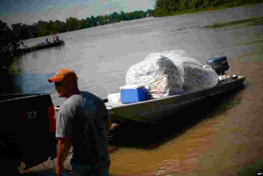 A boat filled with mattresses in Butte LaRose, Louisiana is transported away from floodwaters. (Reuters/Eric Thayer)