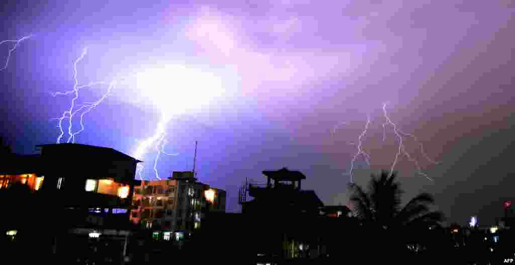 Những tia sét thắp sáng bầu trời đêm trong khi một cơn bão quét qua thành phố Guwahati, Ấn Độ.