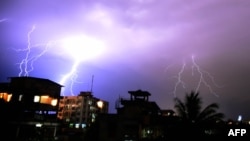 FILE - Lightning illuminates the night sky during a storm over Guwahati, India.