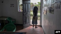Une victime d'un viol collectif quitte les bureaux de la Coalition of Grassroot Women Initiative qui fournit un soutien psychosocial, entre autres services, aux victimes de violences sexuelles dans le bidonville de Dandora à Nairobi, le 16 septembre 2021.