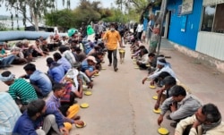 Warga India yang tunawisma dan miskin menerima makanan di penampungan pemerintah di New Delhi, India, Kamis, 26 Maret 2020. (Foto: AP)