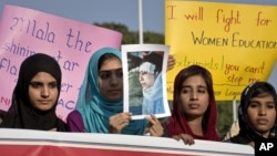Women supporters of a Pakistani religious group 'Minhaj-ul-Quran' hold a poster of schoolgirl Malala Yousufzai, 14, who was shot on Tuesday by the Taliban, during a demonstration in Islamabad, Pakistan, Oct. 13, 2012.