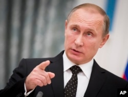 Russian President Vladimir Putin gestures while speaking to the media during his and France's President Francois Hollande news conference following the talks in Moscow, Russia, Nov. 26, 2015.