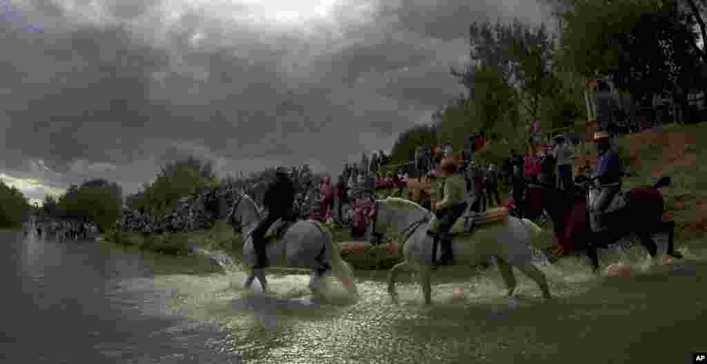 Pilgrims ride their horses crossing the Quema river on their way to the shine of El Rocio in the countryside of Almonte in Huelva province, Spain, May 16, 2013.