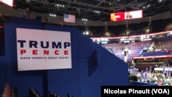 Des participants assis à côté d’une pancarte "Make America great again", le slogan du candidat républicain Donald Trump, Quicken Loans Arena, à Cleveland, Ohio, le 18 juillet 2016. (VOA/Nicolas Pinault).