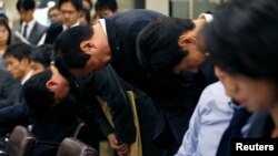 Mizuho Financial Group President Yasuhiro Sato (C) and other company officials bow at a news conference at the Bank of Japan headquarters in Tokyo, Oct. 28, 2013. 