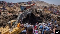 FILE - rescuers work at the scene of a garbage landslide, on the outskirts of the capital Addis Ababa, in Ethiopia. 