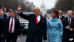 FILE - President Donald Trump and first lady Melania Trump walk along the inauguration day parade route on Pennsylvania Avenue after he was sworn in as the 45th President of the United States, Jan. 20, 2017, in Washington.