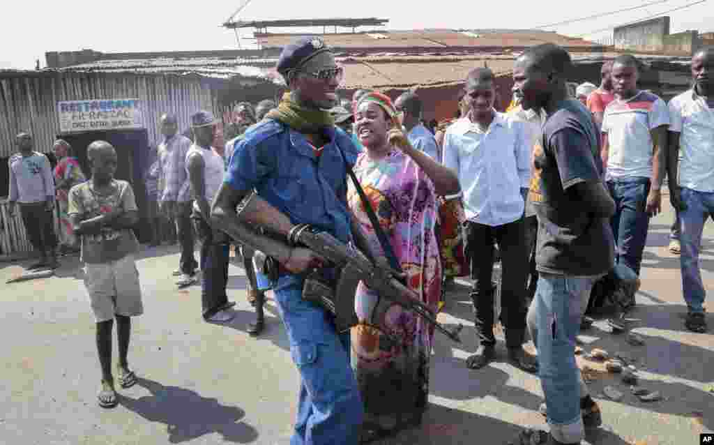 Une femme exprime sa colère à un officier de police après que des parents d&#39;un homme tué par la police &nbsp;ont été empêchés de l&#39;enterrer à temps conformément à ses croyances musulmanes, provoquant la colère dans son quartier, à Bujumbura, Burundi, mercredi 10 Juin 2015.