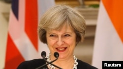 FILE - Britain's Prime Minister Theresa May smiles as her Indian counterpart Narendra Modi (unseen) reads a joint statement at Hyderabad House in New Delhi, India, Nov. 7, 2016.