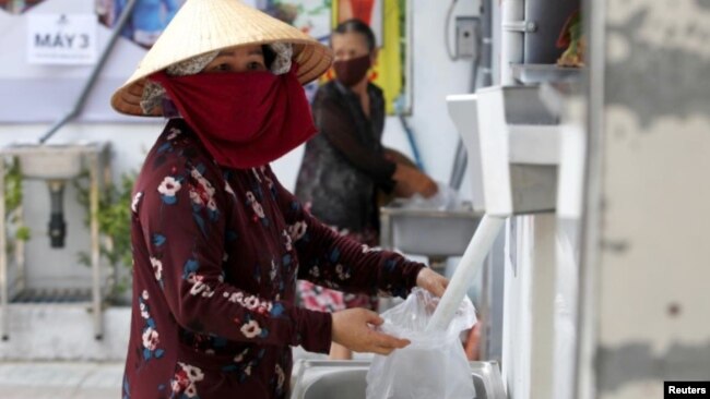 Một phụ nữ nhận gạo từ máy ATM ở TP. Hồ Chí Minh, ngày 11/04/2020.