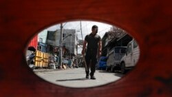 A policeman patrols inside a village that was placed under lockdown as the government implements stricter measures to prevent the spread of the coronavirus in Manila, Philippines on Monday, March 22, 2021.