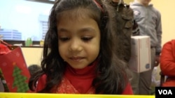 A young Afghan girl looks at her new Play-Doh set.