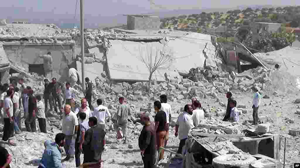 In this citizen journalism image provided by Edlib News Network, ENN, Syrians search under rubble to rescue people from houses that were destroyed by a Syrian government warplane in Idlib province, August 30, 2013.