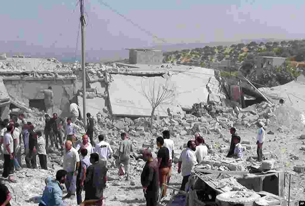 In this citizen journalism image provided by Edlib News Network, ENN, Syrians search under rubble to rescue people from houses that were destroyed by a Syrian government warplane in Idlib province, August 30, 2013.