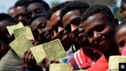 Des Ethiopiens avec leurs cartes d'électeurs. (AFP/ M. Tewelde)