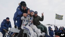 La tripulación aterrizó en una cápsula rusa Soyuz un minuto antes de lo previsto en las estepas cubiertas de nieve de Kazajistán.