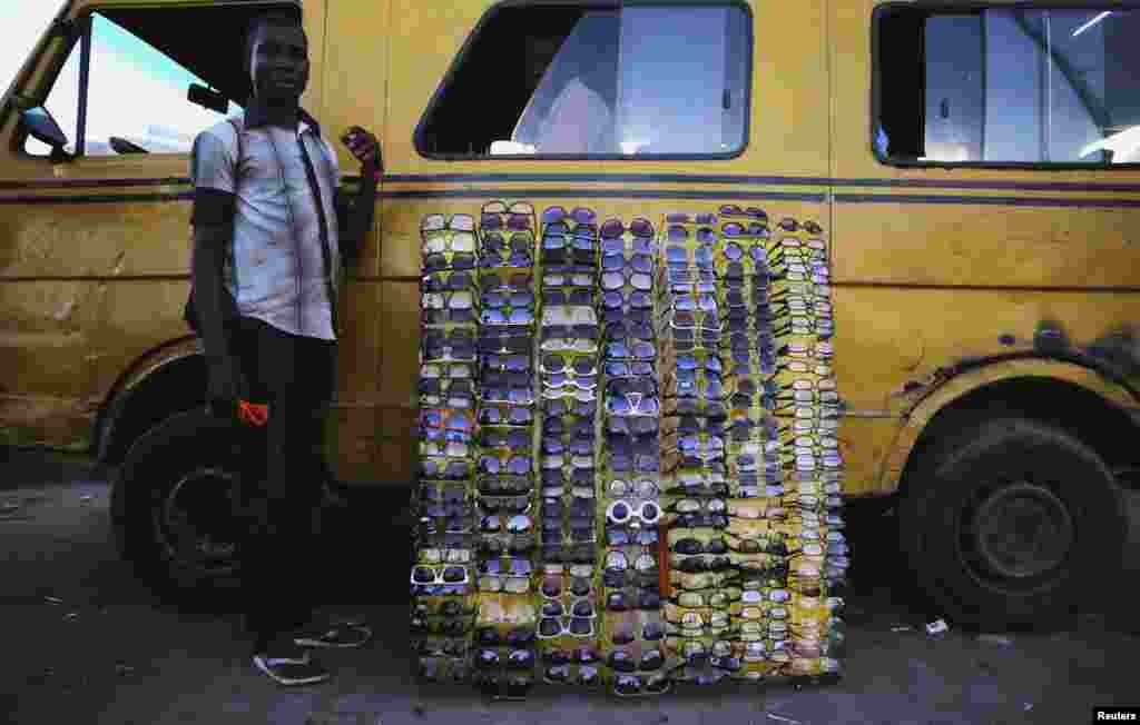 A man selling sunglasses waits for customers at a motor park in the Obalende district of Lagos.