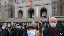 Jim Nickel, center, the deputy chief of mission for the Canadian Embassy in China, and foreign diplomats gather outside the No. 2 Intermediate People's Court as they arrive to attend former diplomat Michael Kovrig's trial in Beijing, March 22, 2021