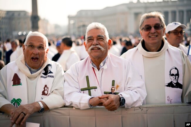Sacerdotes vestidos con la imagen del asesinado arzobispo salvadoreño Oscar Romero asisten a una ceremonia de canonización en la Plaza de San Pedro en el Vaticano, 14 de octubre de 2018.