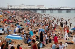 Visitors play on Brighton beach during hot summer weather, near Brighton Pier in Brighton, Britain, July 25, 2019.