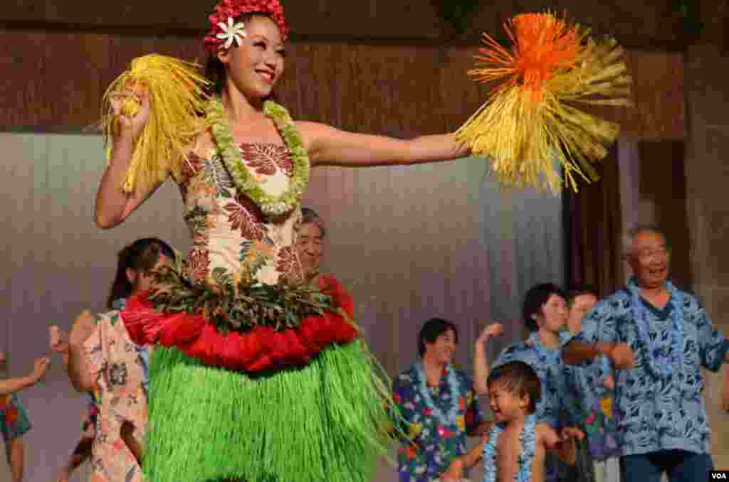 Resort guests join dancers on stage for a hula lesson, October 25, 2012. (Steve Herman/VOA)