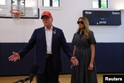 El candidato presidencial republicano y expresidente de EEUU, Donald Trump, acompañado por la exprimera dama, Melania Trump, habla con los periodistas mientras vota en el Centro de Recreación Mandel el día de las elecciones en Palm Beach, Florida, el 5 de noviembre de 2024.