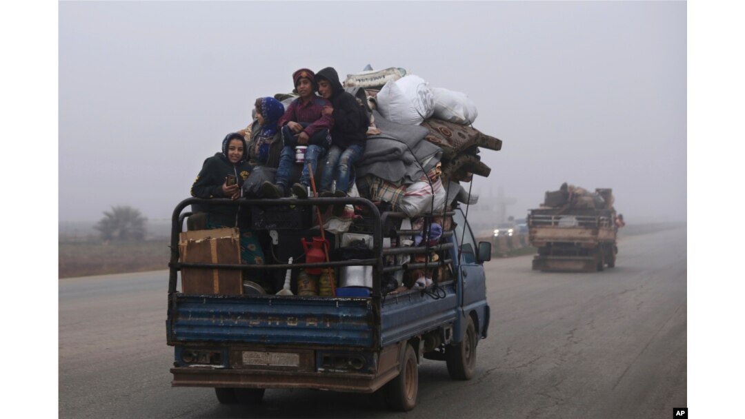 FILE - Civilians ride in a truck as they flee Maaret al-Numan, Syria, ahead of a government offensive on Dec. 23, 2019.
