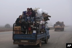 FILE - Civilians ride in a truck as they flee Maaret al-Numan, Syria, ahead of a government offensive on Dec. 23, 2019.