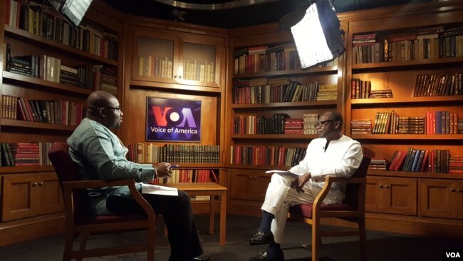 Ghana's finance minister, Ken Ofori-Atta, at right, speaks with VOA's Peter Clottey.