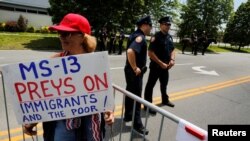 Archivo - Una simpatizante del presidente de Estados Unidos, Donald Trump, sostiene un cartel que dice que la MS-13 caza a inmigrantes y pobres, en un evento realizado en Bethpage, Nueva York en mayo 23, 2018.