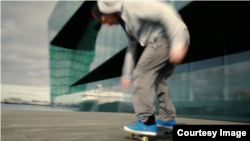 A skateboarder rolls past what is apparently Reykjavik's Harpa concert hall in a screen grab from a promotional video for the U.S. state of Rhode Island. (Rhode Island Commerce Corporation)(