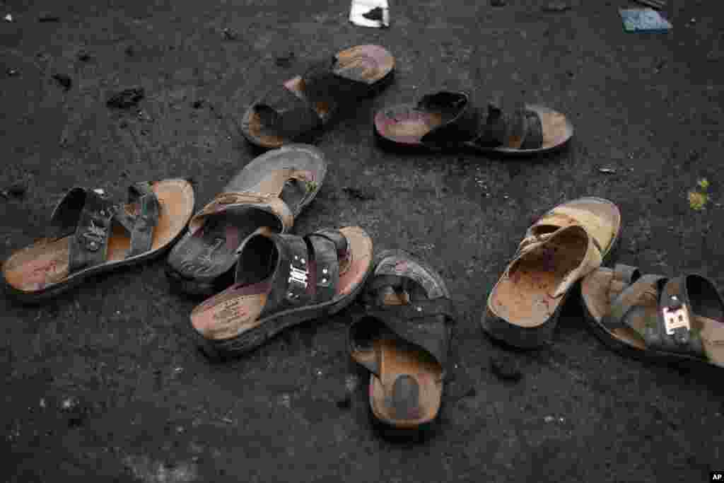 Sandals with blood stains are seen at the site of a suicide bombing as Yemeni security officials gather debris in Sana&#39;a, Oct. 9, 2014. 