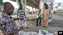 Wani mutum da ba'a tantance dashi bane ke karanta kanun labarun wata Jaridar da aka rubuta "an dai ji kuna", bayan da shugaban hukumar zaben Nigeria Attahiru Jega ya bada sanarwar dage gudanar da babban zabe, jiya lahadi, 3 ga watan Afrilun shekarar 2011