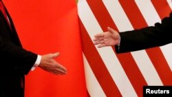 FILE - U.S. President Donald Trump and China's President Xi Jinping shake hands after making joint statements at the Great Hall of the People in Beijing, China, Nov. 9, 2017. 