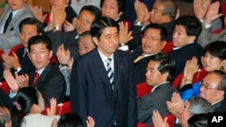 FILE - Shinzo Abe acknowledges applause from the Liberal Democratic Party lawmakers as he won a landslide victory Sept. 20, 2006 in Japan's ruling party presidential vote at the LDP headquarters in Tokyo.