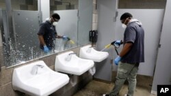미국 아이오와주 디모인의 샌트럴캠퍼스 고등학교에서 교직원이 남자 화장실 방역 작업을 하고 있다. 