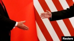 FILE - U.S. President Donald Trump and China's President Xi Jinping shake hands after making joint statements at the Great Hall of the People in Beijing, Nov. 9, 2017. 